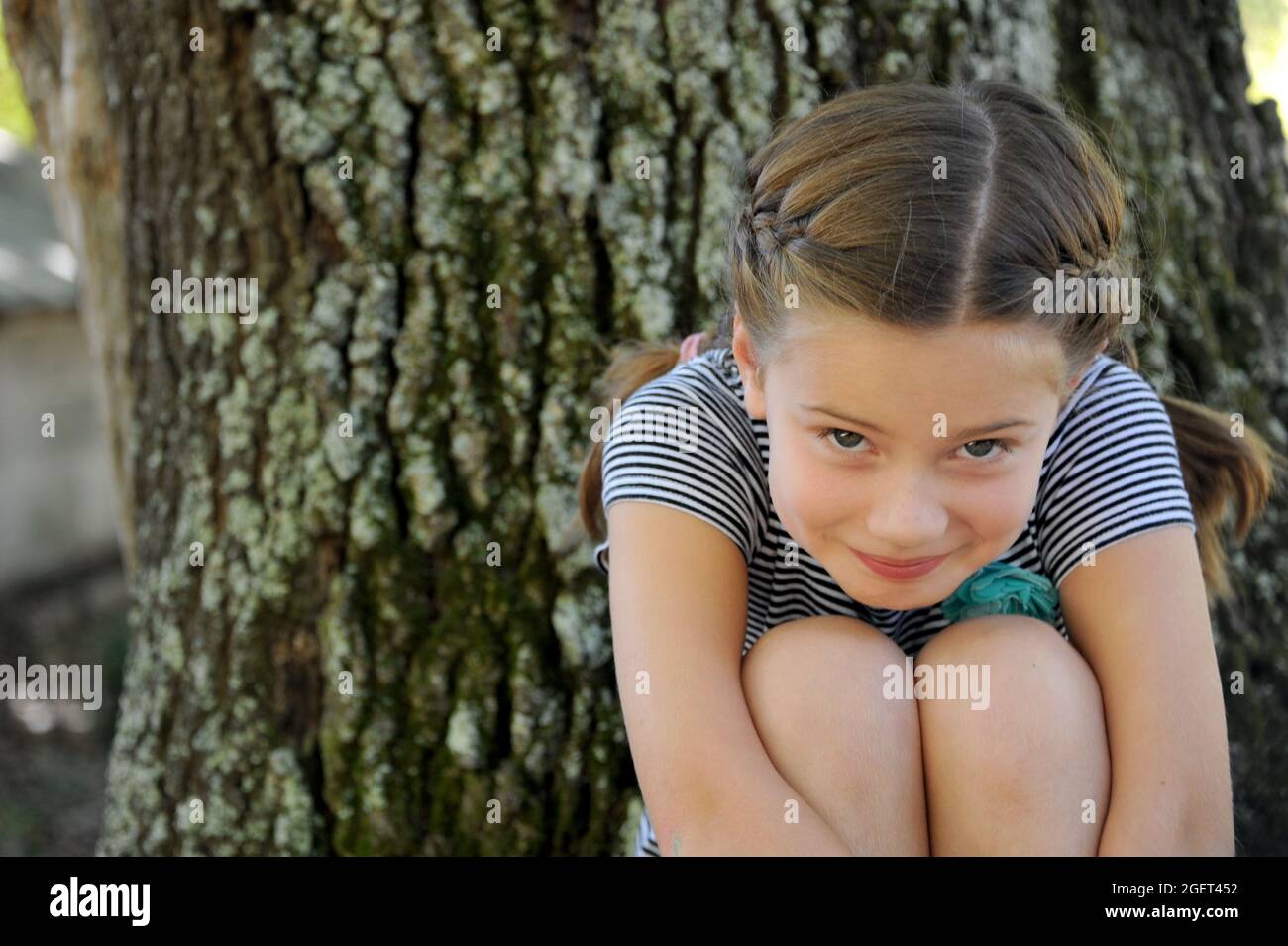 Girl sitting knees up smiling hi-res stock photography and images - Alamy