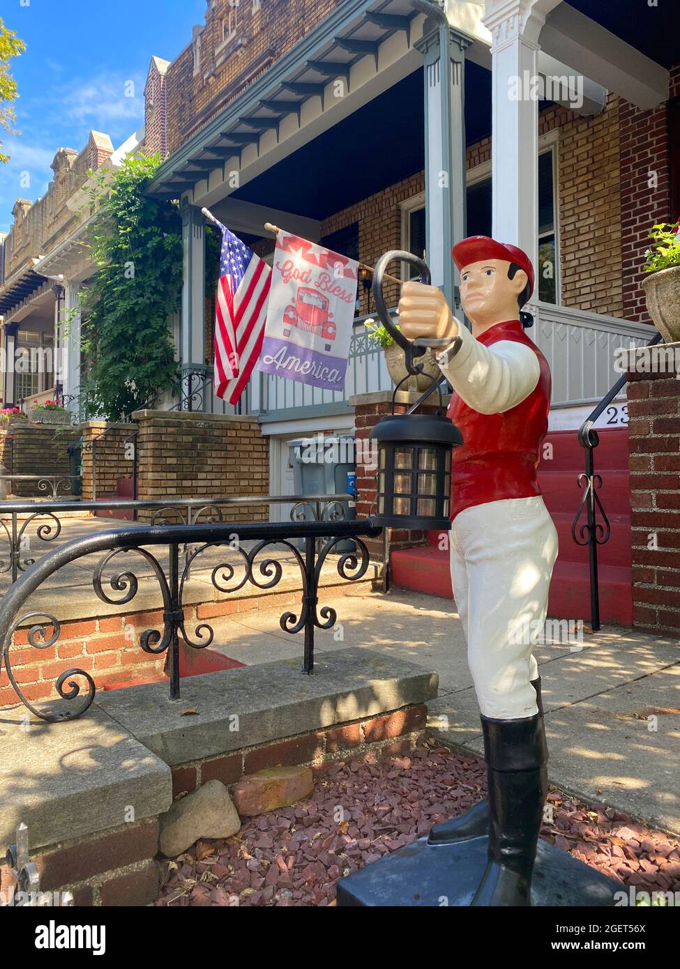 Classic painted lawn jockey with patriotic flags in the rear in the
