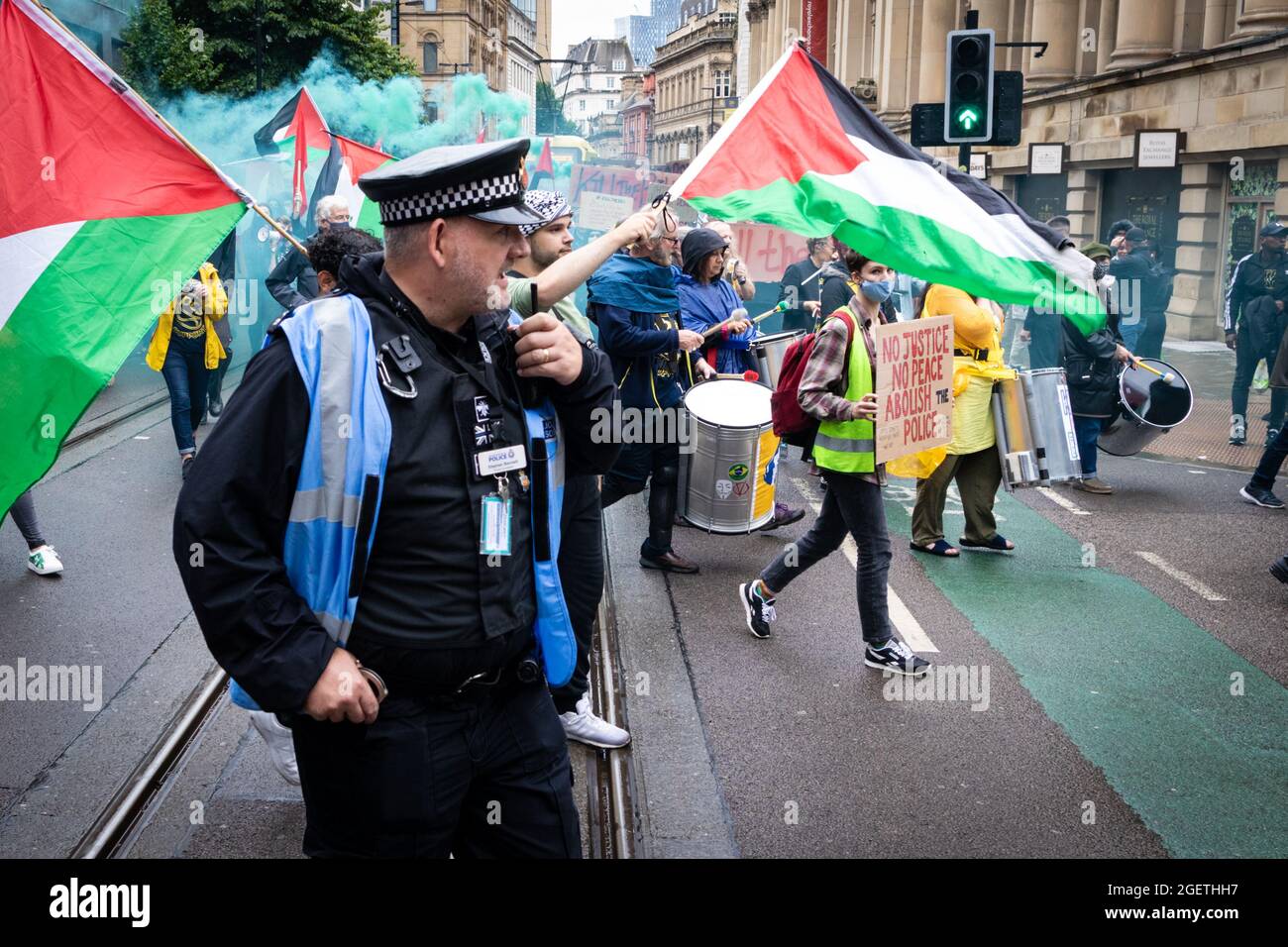 Manchester, UK. 21st Aug, 2021. A police liaison officer walks next to the Kill The Bill march. Protests across the country have been organised due to the proposed Police, Crime and Sentencing Bill that, if passed, would introduce new legislation around demonstrations. Credit: Andy Barton/Alamy Live News Stock Photo