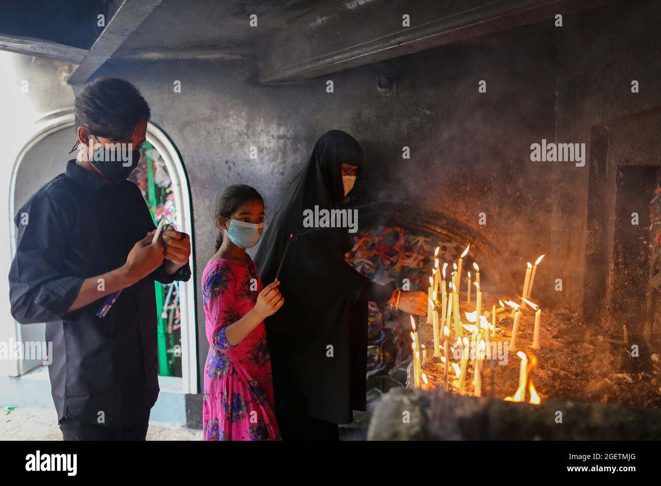 DHAKA, BANGLADESH, AUGUST 20: A Shia muslim woman lights a candle and pray for imam hussain, at Husani-dalan. Musilm People take part during  a religious procession in the month of Muharram on the occasion to commemorate  Ashura Day. Ashura is the tenth day of Muharram, the first month of the Islamic calendar commemorating the martyrdom of Imam Hussein, the grandson of the Prophet hazrat Muhammad. On August 20, 2021 in Dhaka, Bangladesh. (Photo by Eyepix/Sipa USA) Stock Photo