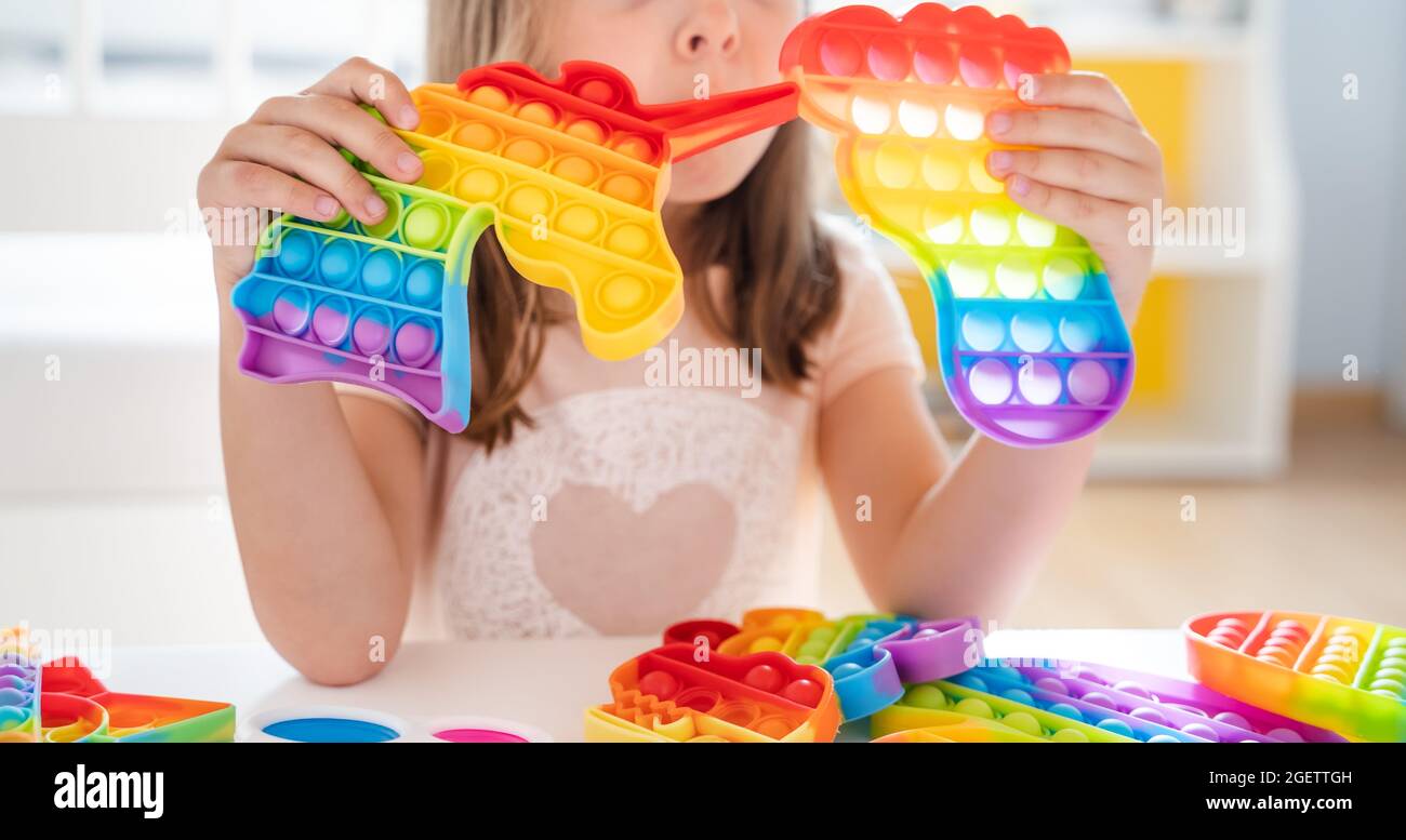 Little girl,kid,child plays with colorful pop it children's room,  bedroom.Funny trendy silicone antistress colorful sensory push toy popit.Flapping  fi Stock Photo - Alamy