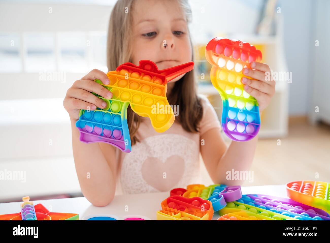 Little girl,kid,child plays with colorful pop it children's room ...