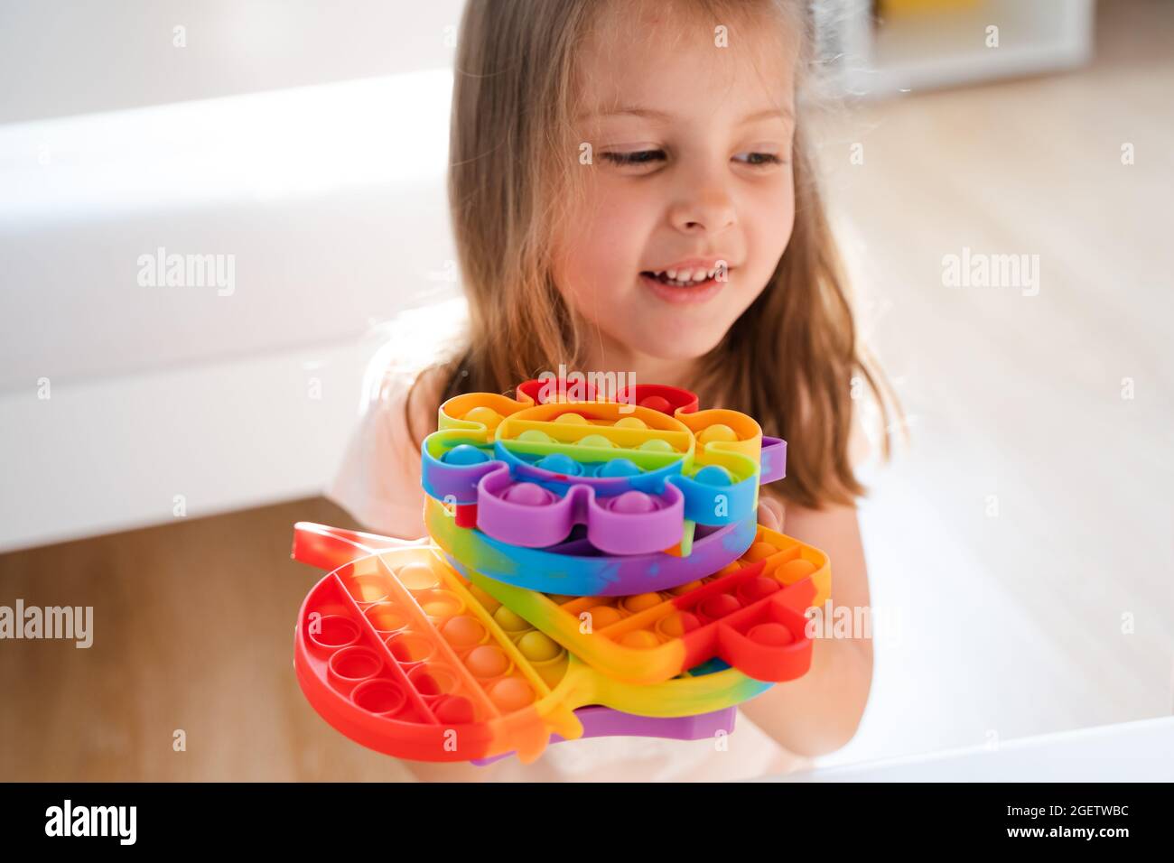 Little girl,kid,child plays with colorful pop it children's room,  bedroom.Funny trendy silicone antistress colorful sensory push toy popit.Flapping  fi Stock Photo - Alamy