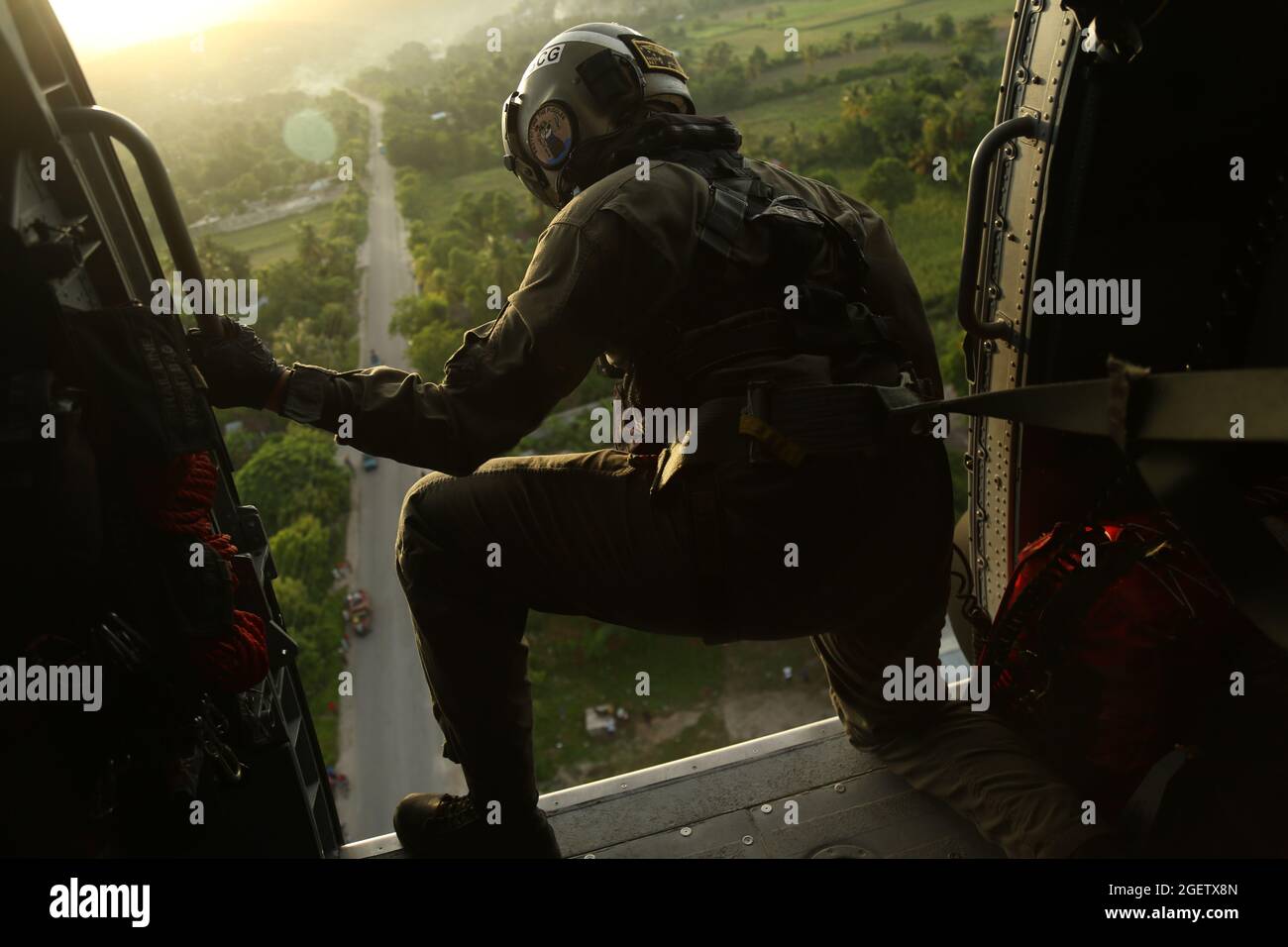 Cavaillon, Haiti. 21st Aug, 2021. U.S. Coast Guard PO2 Sherri Helgoe clears a path to land to provide medical evacuations in the aftermath of the 7.2 magnitude earthquake August 21, 2021 in Cavaillon, Haiti. Credit: Planetpix/Alamy Live News Stock Photo