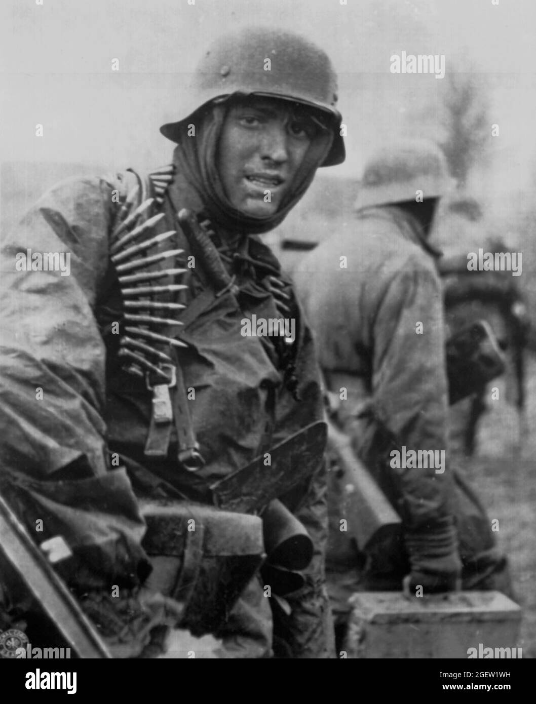 ARDENNES, BELGIUM - December 1944 - A Geman soldier, heavily armed, carries ammunition boxes forward with companion in territory taken by their counte Stock Photo