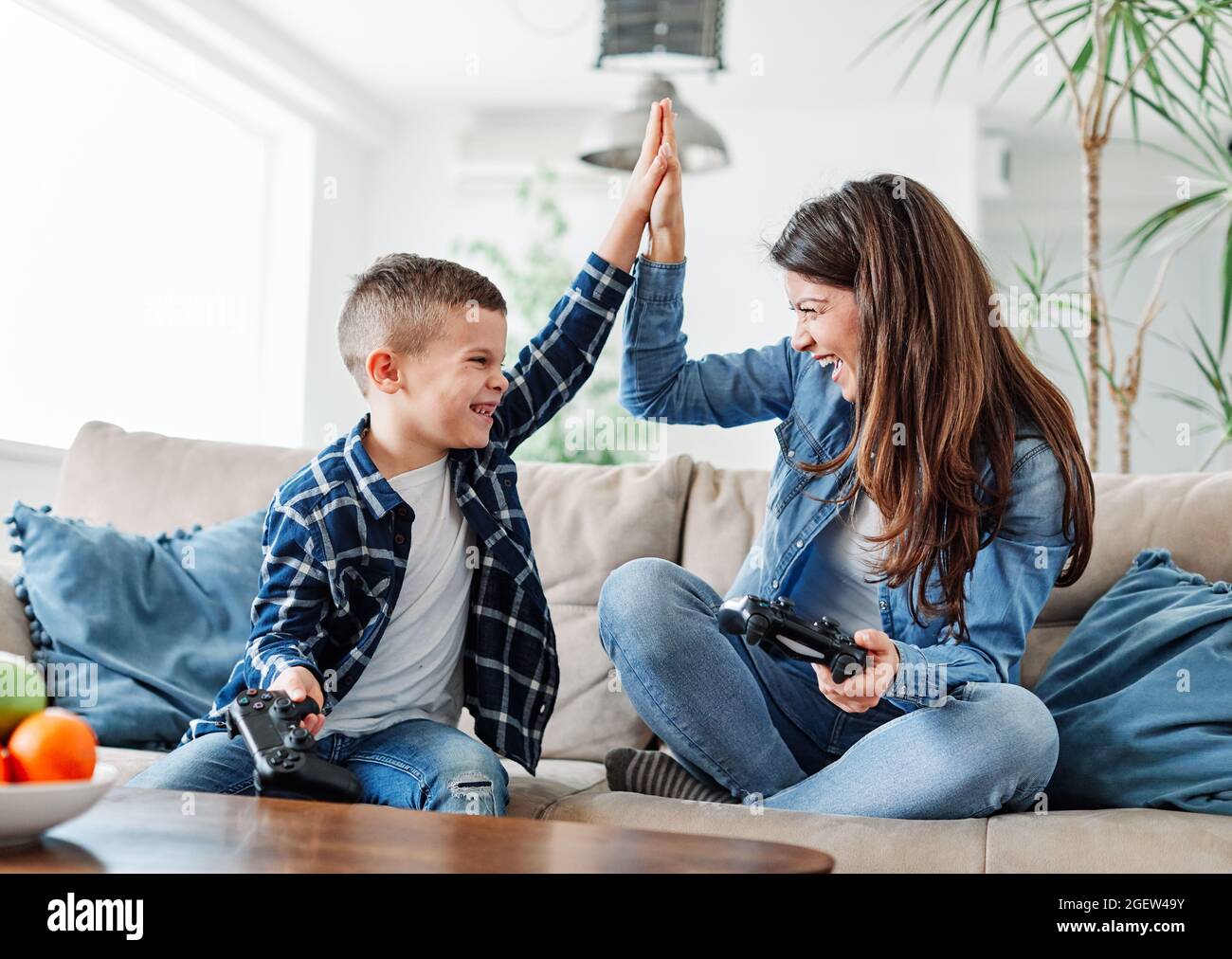 child son mother family happy playing console kid childhood Stock Photo