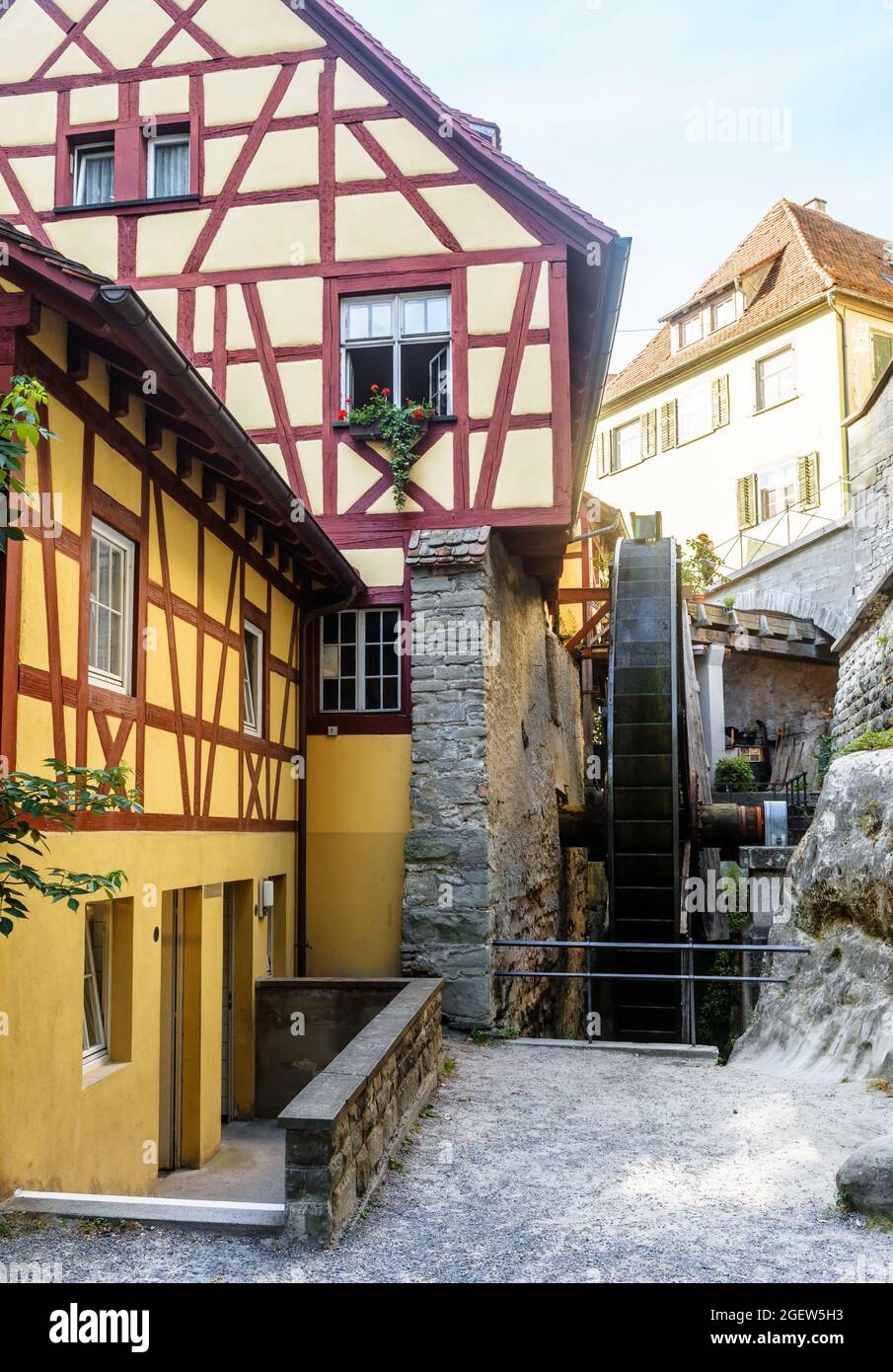 Water mill in Meersburg, Germany. Vertical view of old half-timbered houses and medieval mill wheel. This place is tourist attraction of city. Concept Stock Photo