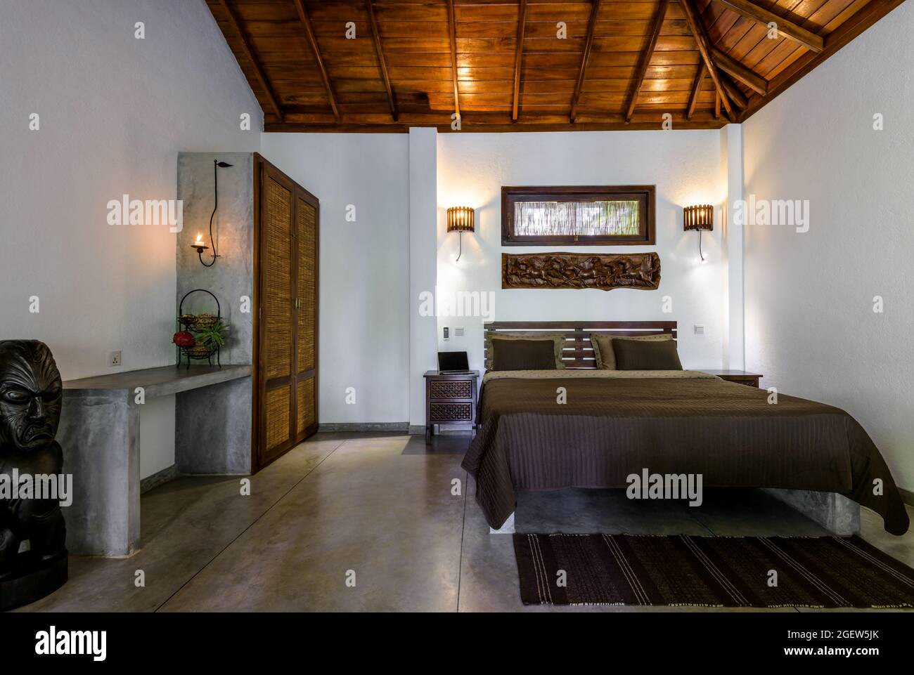 Tangalle, Sri Lanka – Oct 31, 2017: Inside hotel or residential house, room with bed, wooden furniture and ceiling. Bedroom home interior in Indian mi Stock Photo