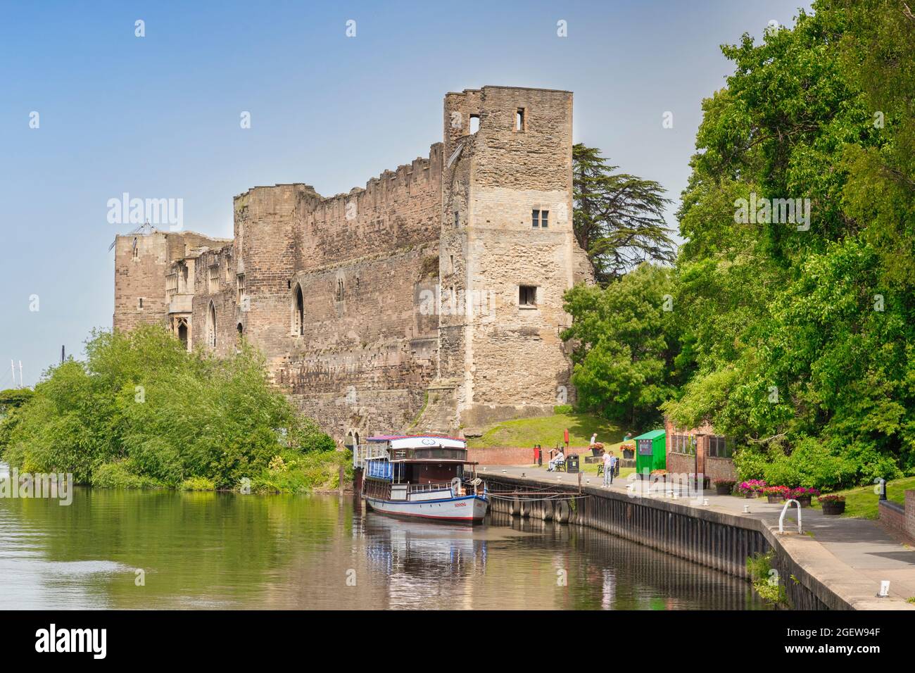 4 July 2019: Newark-on-Trent, Nottinghamshire, UK - Newark Castle and the River Trent in summer. Tour boat moored at the quay, people on path beside i Stock Photo