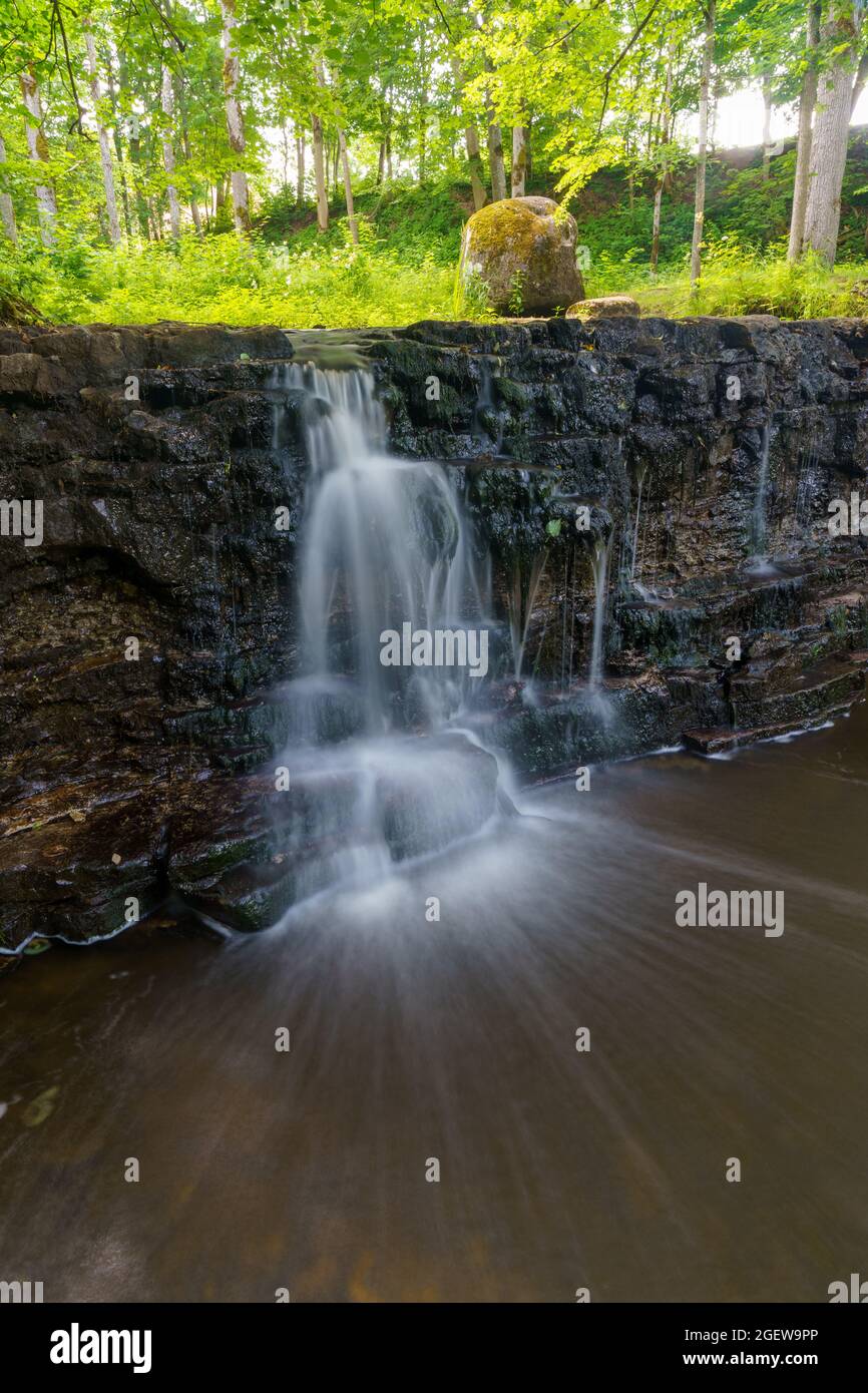 Ivande waterfall with a small stream of water photographed in a long exposure, which allows the water to flow out.  In the background you can see tree Stock Photo