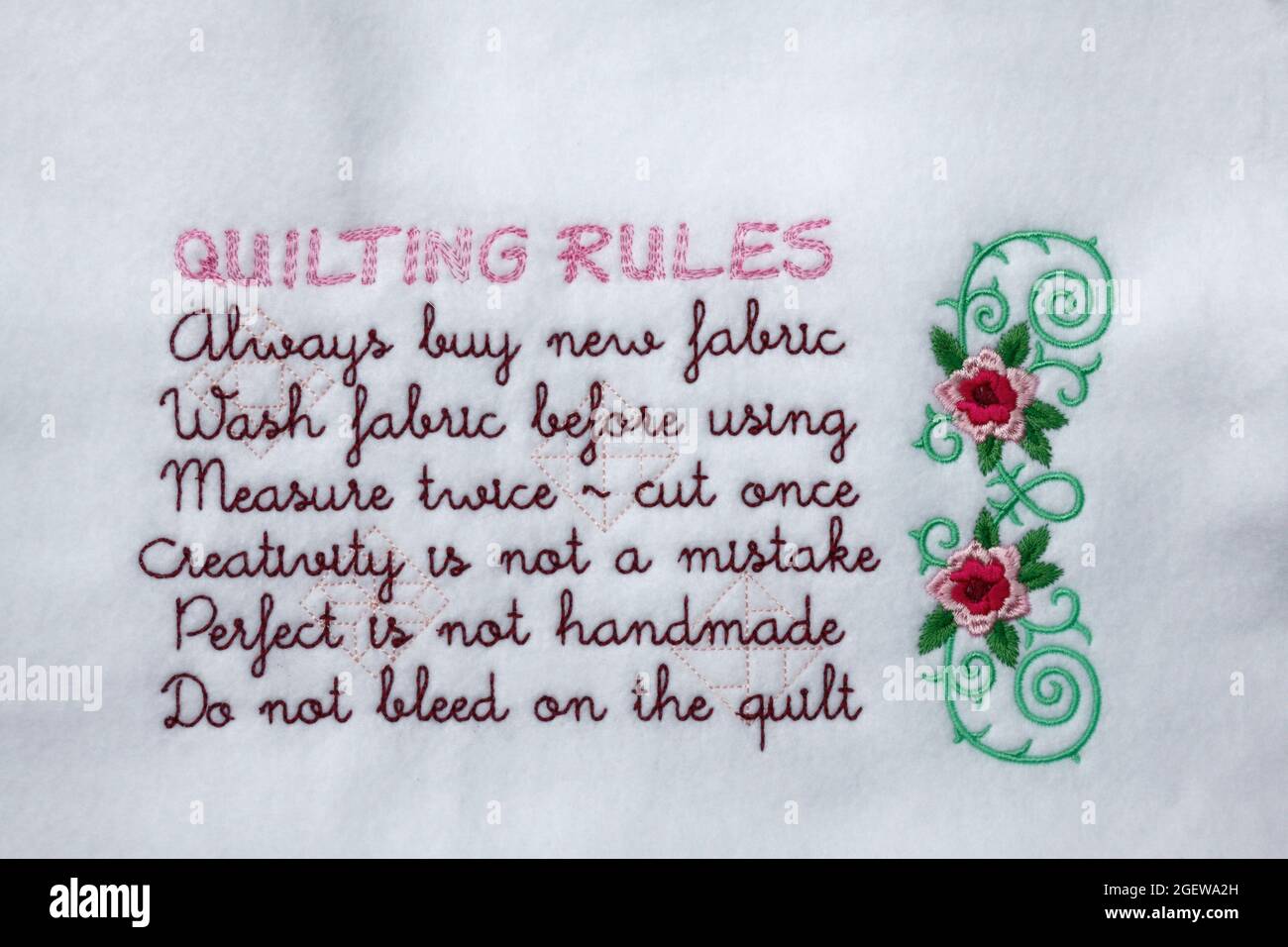 Quilting Rules embroidery, white felt fabric, wall decoration, craft, flower embellishment, needlework, text, words, PR Stock Photo