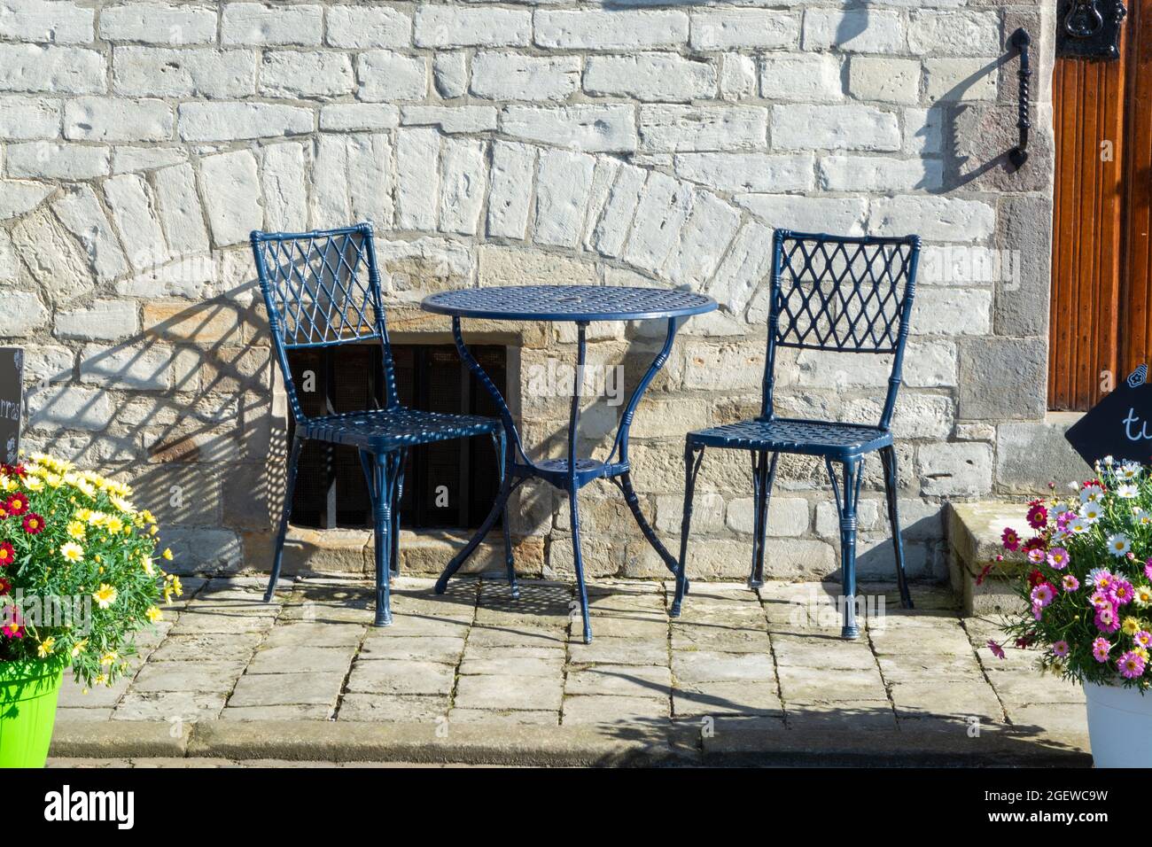 Vintage metal bistro table and chairs set in outdoor cafe, used for breakfast, lunch and dinner ...