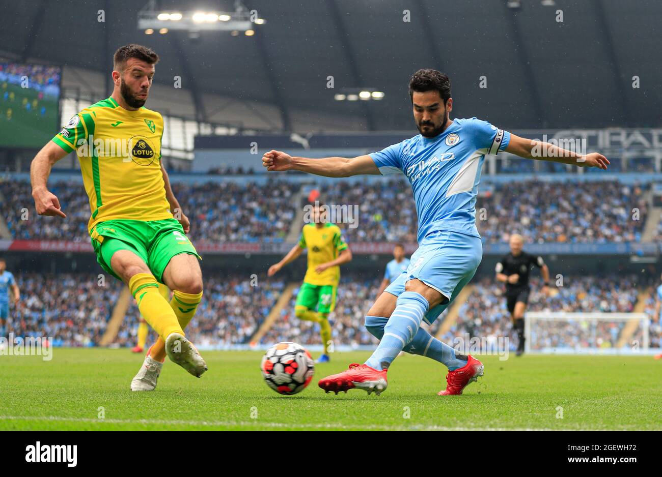 Ilkay Gundogan #8 of Manchester City crosses the ball watched by Grant Hanley #5 of Norwich City Stock Photo