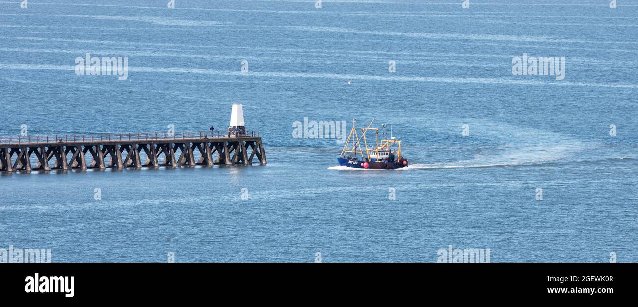 A fishing trawler returning to port at Maryport Stock Photo