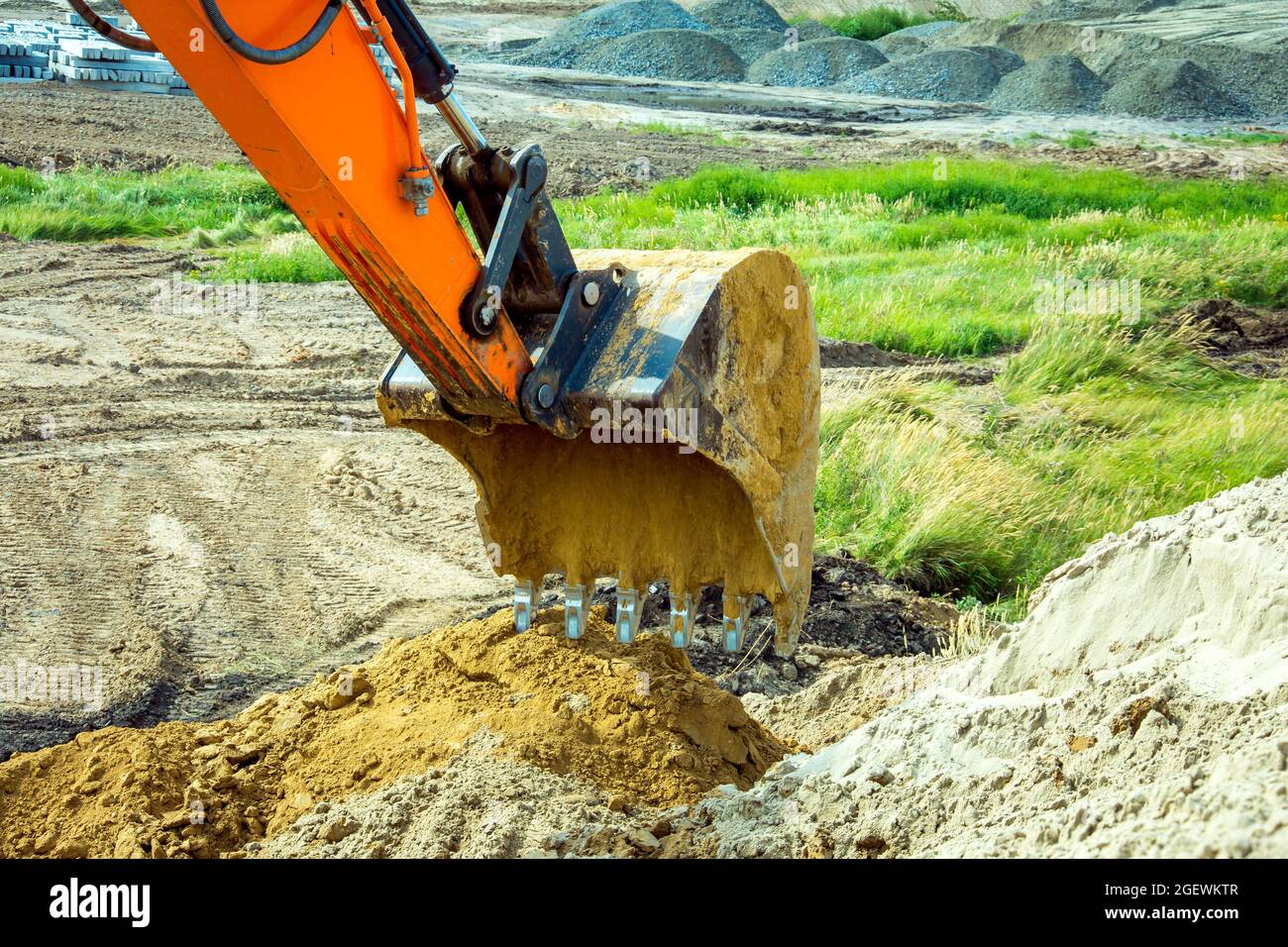 Closeup bucket of backhoe digging the soil at construction site