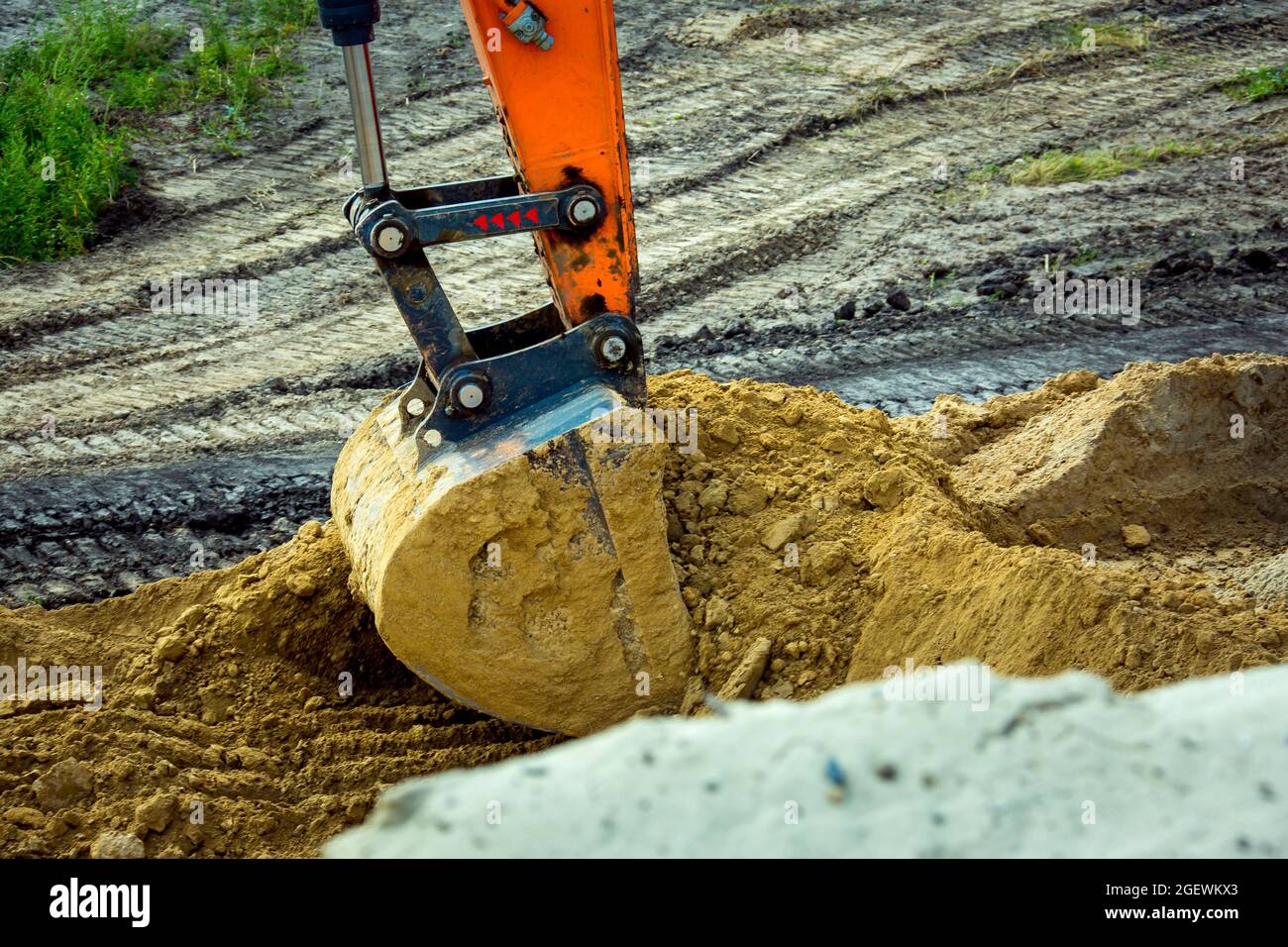 Closeup bucket of backhoe digging the soil at construction site