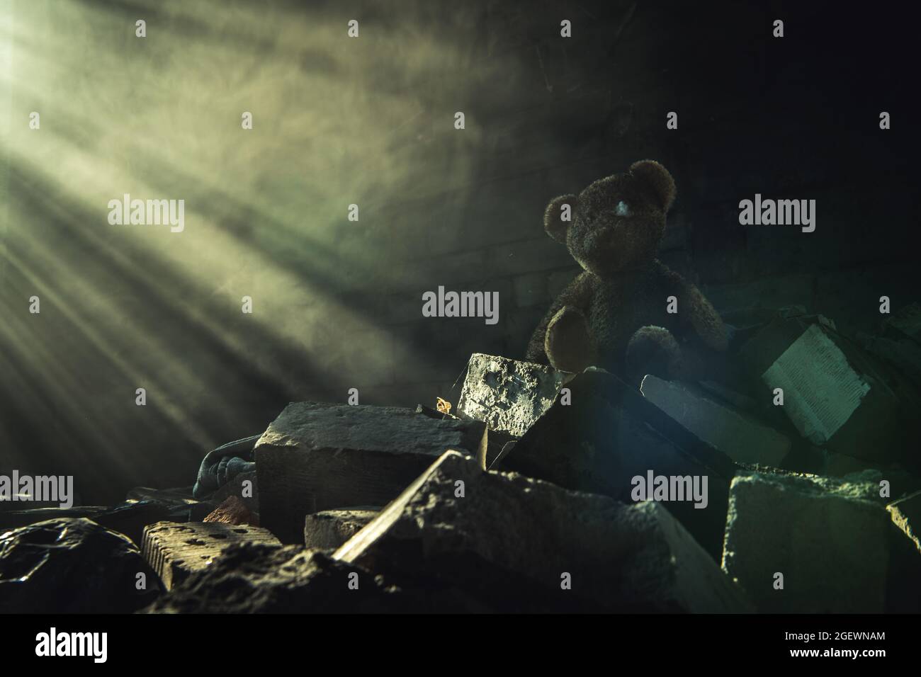 Dirty Damaged Teddy Bear Inside Abandoned House Ruins Brighten Up by Sunlight Coming Through a Structure Window Giving New Hopes. Stock Photo