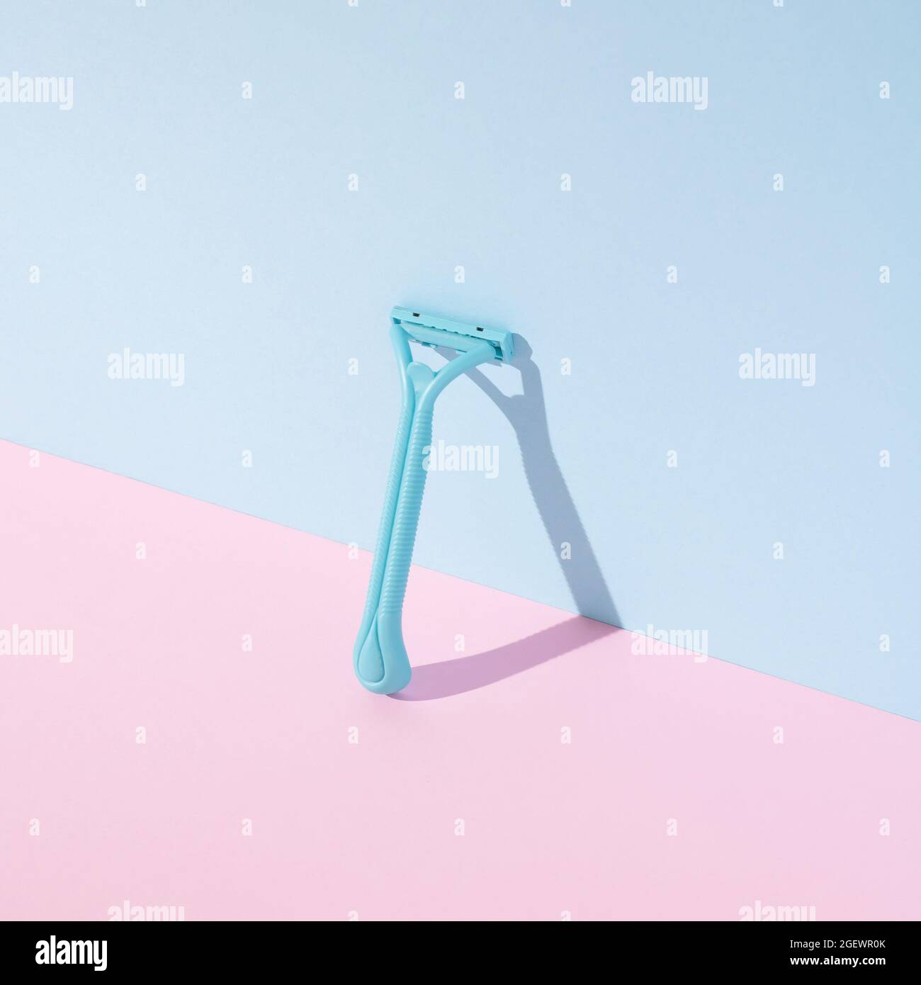 Plastic beard razor with shadow on pastel pink and blue background ...