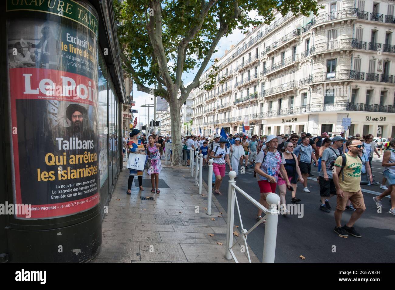 Demonstrators are seen passing a poster of the French newspaper "Le Point" which headlines the Taliban takeover in Afghanistan, during the protest.Saturday 21 August 2021 is the sixth day of mobilization against the vaccine policy and the application of the health pass. In Toulon (Var), according to the authorities there were 6000 demonstrators. The main slogans criticize the government decisions as dictatorial. Some of the placards included signs and slogans comparing the current situation with the Nazi regime and the Second World War. Stock Photo