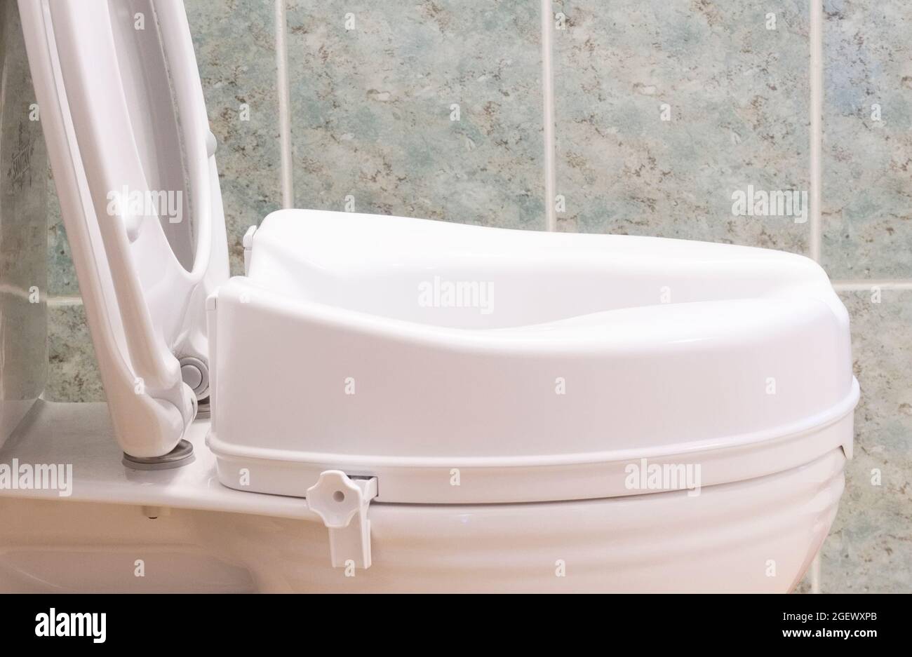 Toilet with height extension for disabled senior person indoors in