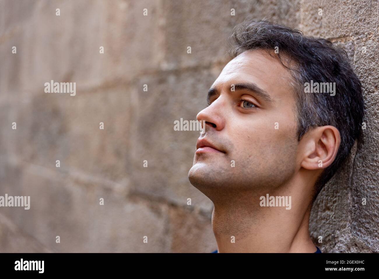 Young latin thoughtful man against a wall outdoors Stock Photo