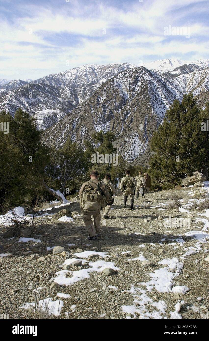 U.S. Navy SEALs search for al-Qaida and Taliban  while conducting  a Sensitive Site Exploitation mission in the Jaji Mountains, Jan. 12, 2002. Navy Special Operations Forces are conducting missions in Afghanistan in support Operation Enduring Freedom. (U.S. Navy photo by Petty Officer 1st Class Tim Turner) Stock Photo