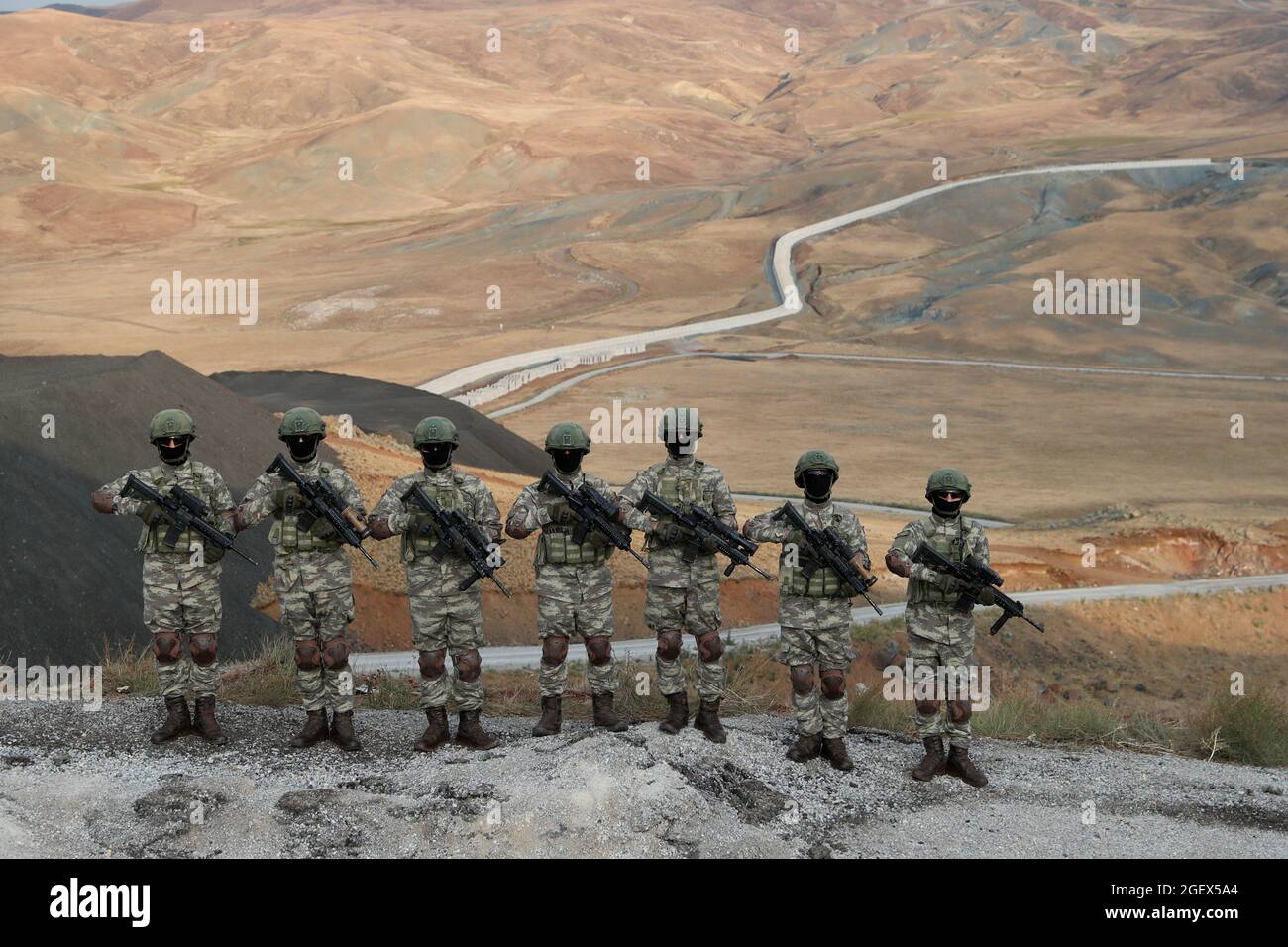 Turkish commandos, with a wall on the border line between Turkey and Iran  in the background,