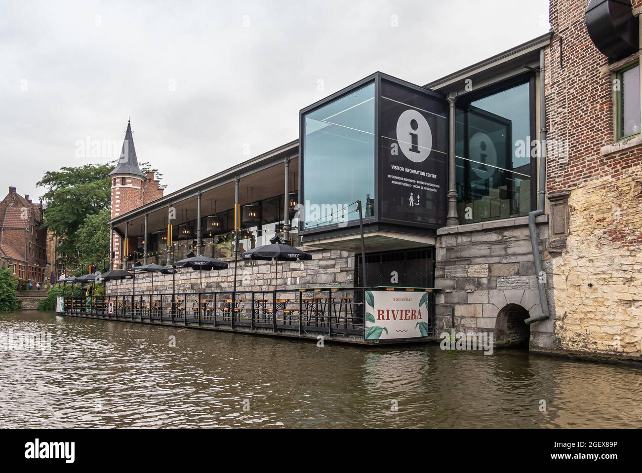 Gent, Flanders, Belgium - July 30, 2021: Leie side of modern Riviera  restaurant and Gent tourist information office under grey sky. Medieval  tower and Stock Photo - Alamy