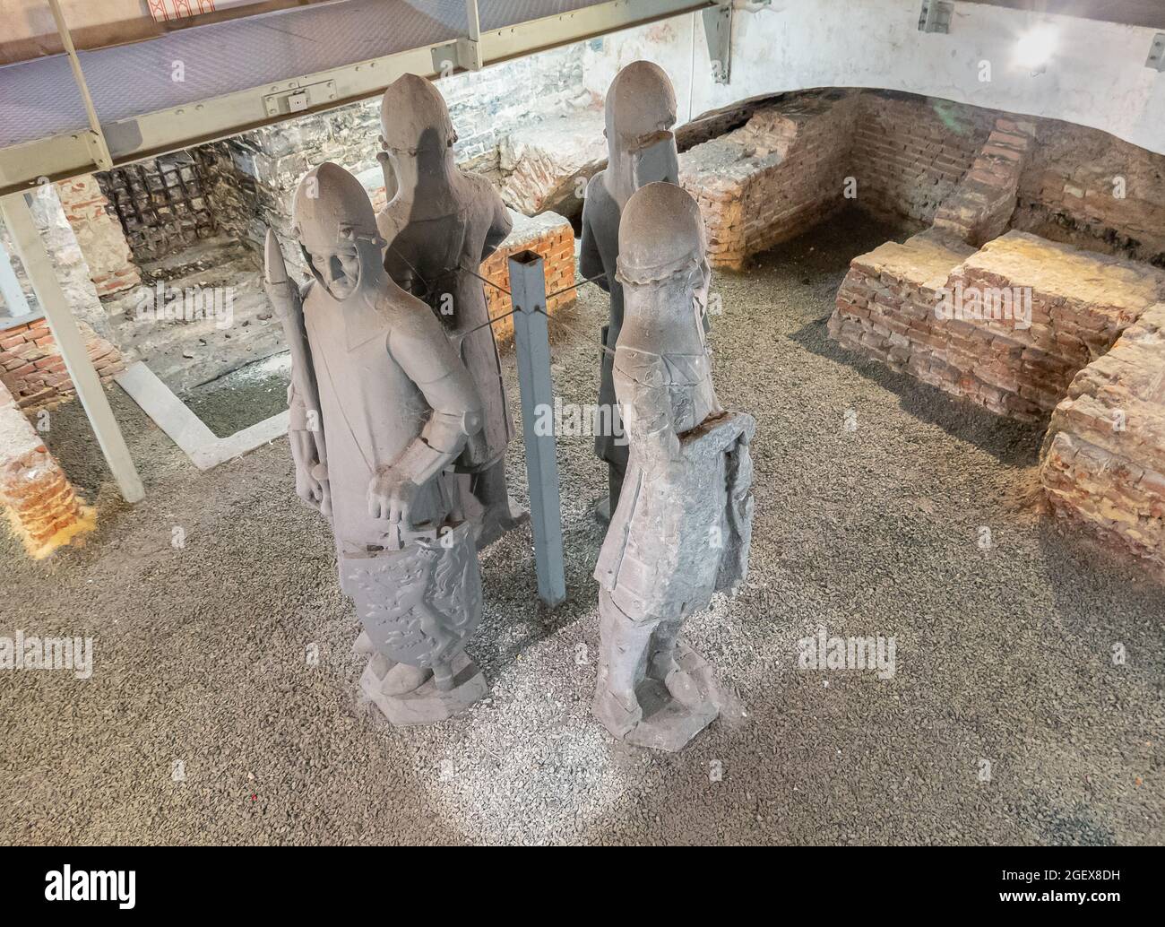 Gent, Flanders, Belgium - July 30, 2021: Gray stone statues of medieval soldiers at excavation site under Belfry. Old red brick fundaments are exposed Stock Photo