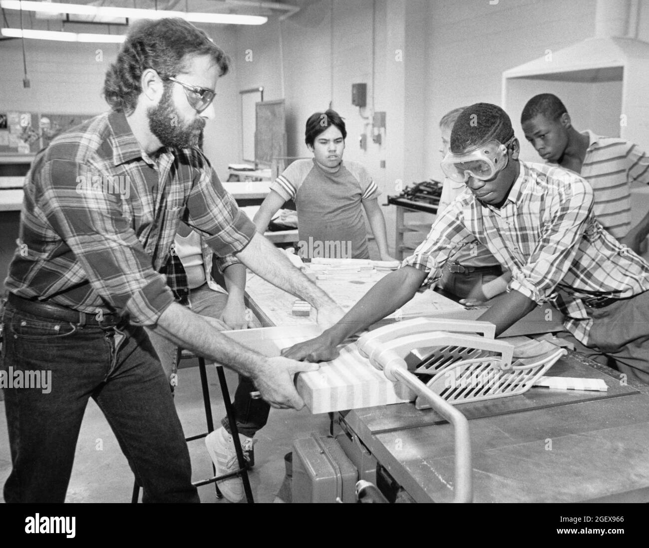 Austin Texas USA, circa 1992: Male shop teacher at Kealing Junior High helps student use table saw to  make kitchen cutting board as gift. ©Bob Daemmrich Stock Photo
