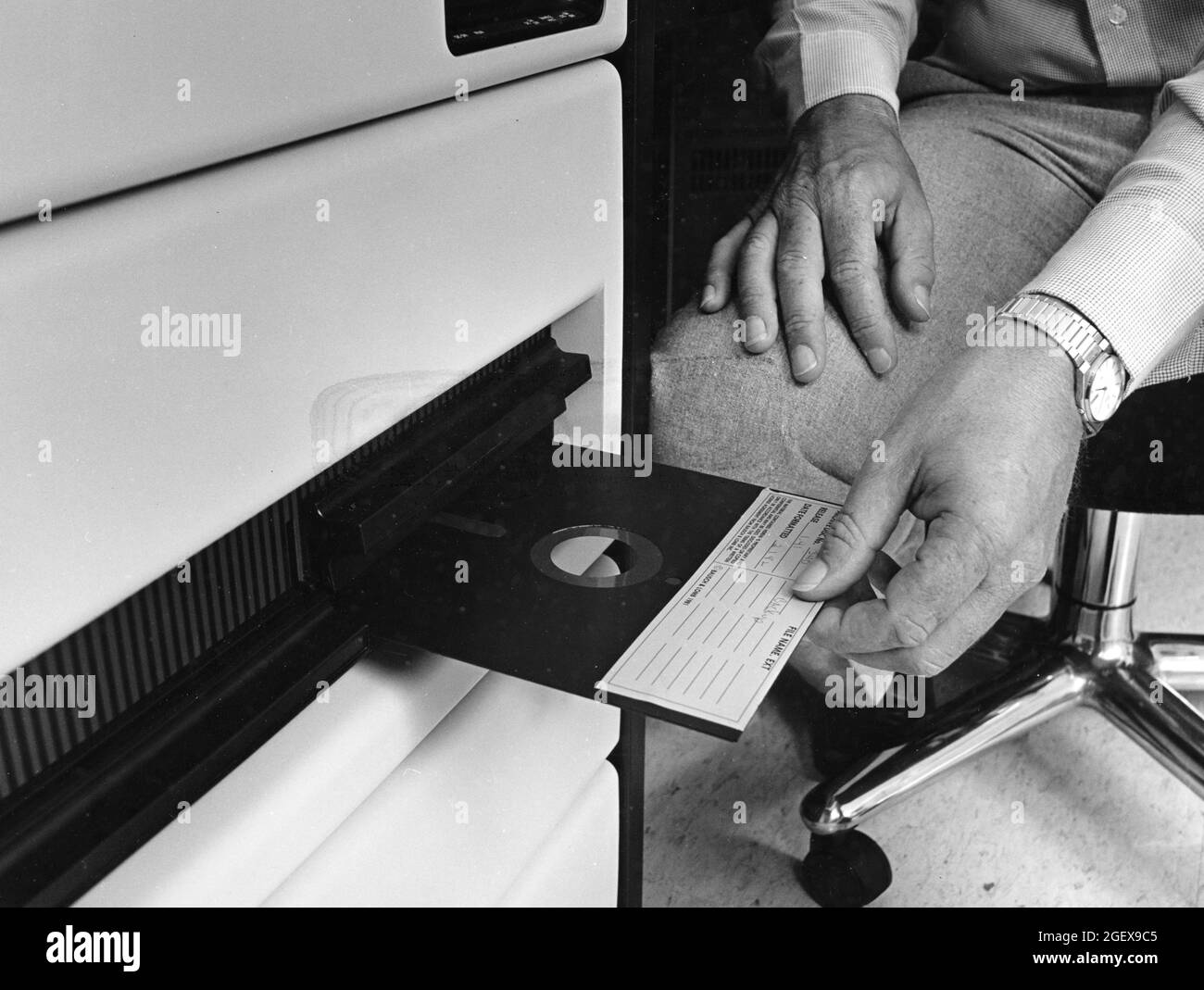 Austin Texas USA, circa 1990: Worker inserts a 5.25-inch floppy disk, made by Bausch & Lomb, into a CAD computer workstation. ©Bob Daemmrich Stock Photo