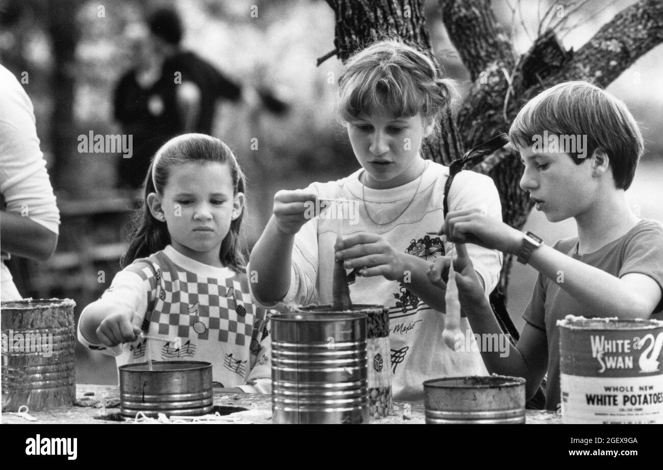 Austin Texas USA, circa 1989: Children making candles in the manner of early Texas settlers at the Pioneer Farm folklife festival.   Original in color   ©Bob Daemmrich Stock Photo