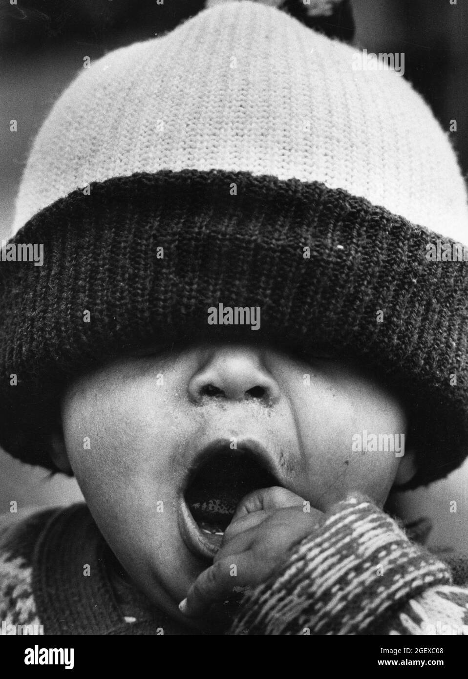 Bryan, Texas USA, circa 1978: Little boy wearing big knit cap yawns. ©Bob Daemmrich Stock Photo
