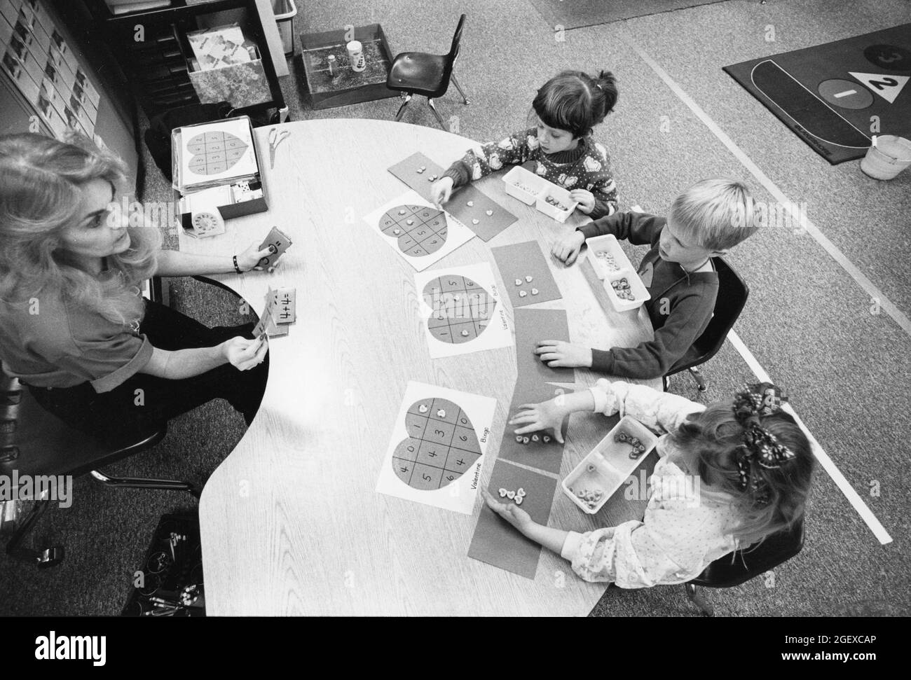 Austin Texas USA, 1994: Kindergarten children practice math skills  by adding and subtracting with Valentine candy,  MR EI-0044  ©Bob Daemmrich Stock Photo