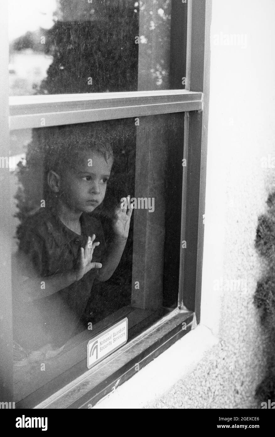 Austin Texas USA, circa 1999: Pre-school boy  looks out window of  day care building. MR  Creative World Day Care. ©Bob Daemmrich Stock Photo