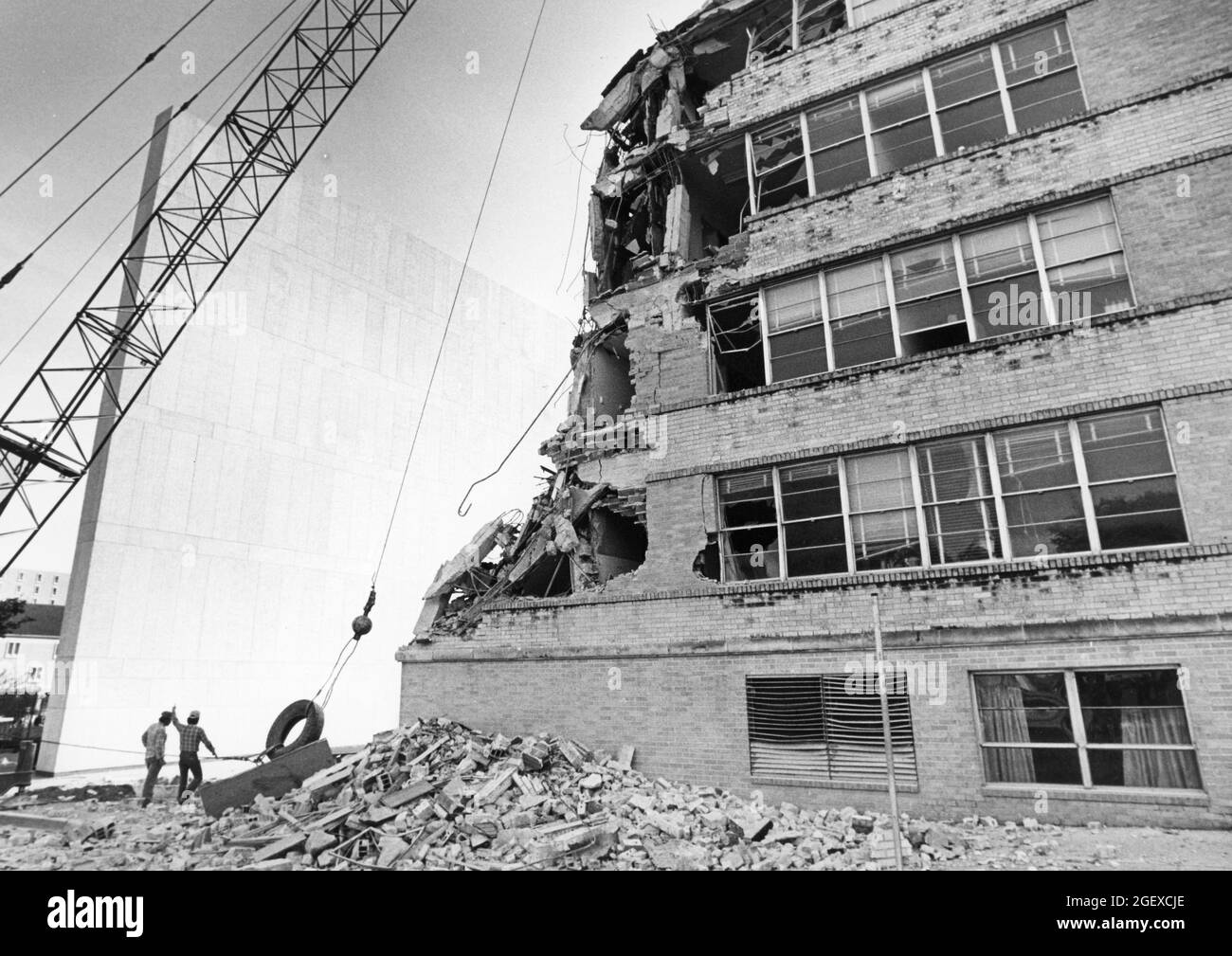 Dallas Texas USA, circa 1991: Wrecking ball attached to a crane helps with demolition of brick office building near downtown. ©Bob Daemmrich Stock Photo