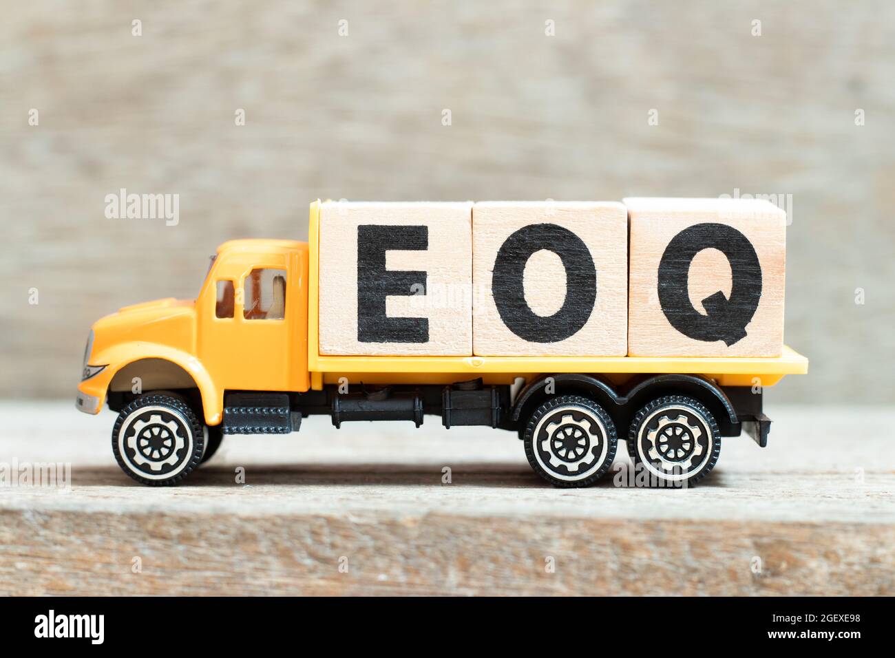 Toy truck hold alphabet letter block in word EOQ (Abbreviation of Economic order quantity) on