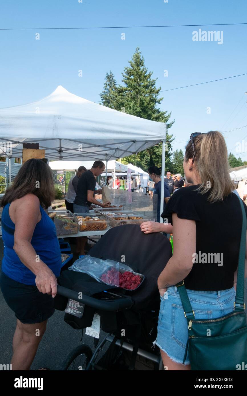 Customers wait in line to make purchases from Bodhi's Artisan Bakery at the Qualicum Beach, British Columbia, Canada farmer's market Stock Photo