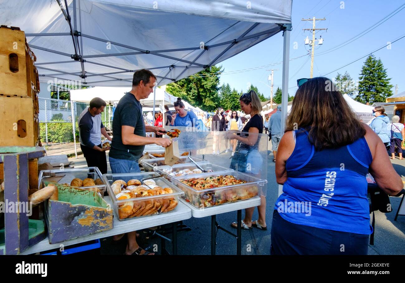 Customers wait in line to make purchases from Bodhi's Artisan Bakery at the Qualicum Beach, British Columbia, Canada farmer's market Stock Photo