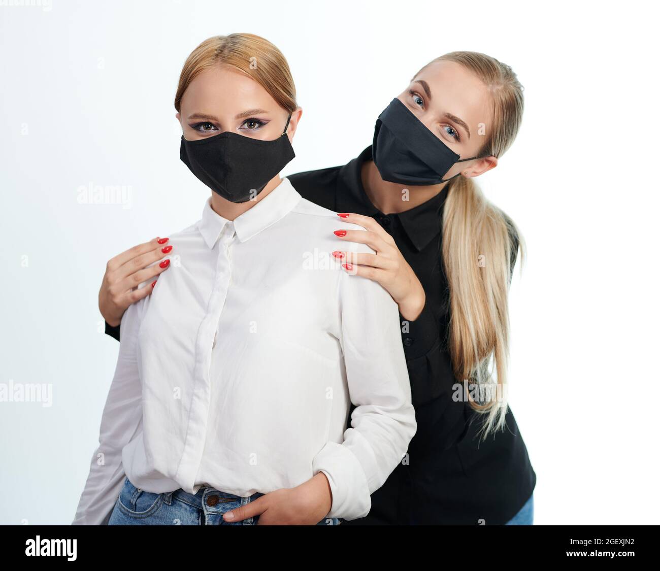 Two pretty girls in mask isolated on white studio background Stock Photo