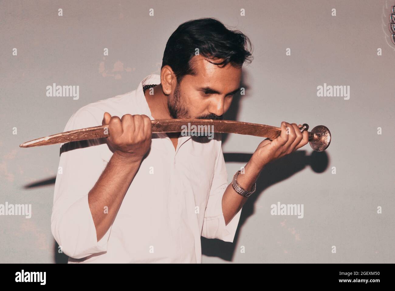 Kshatriya youth, wearing white kurta while shooting photo with sword. Indian hindu traditional costumes Stock Photo