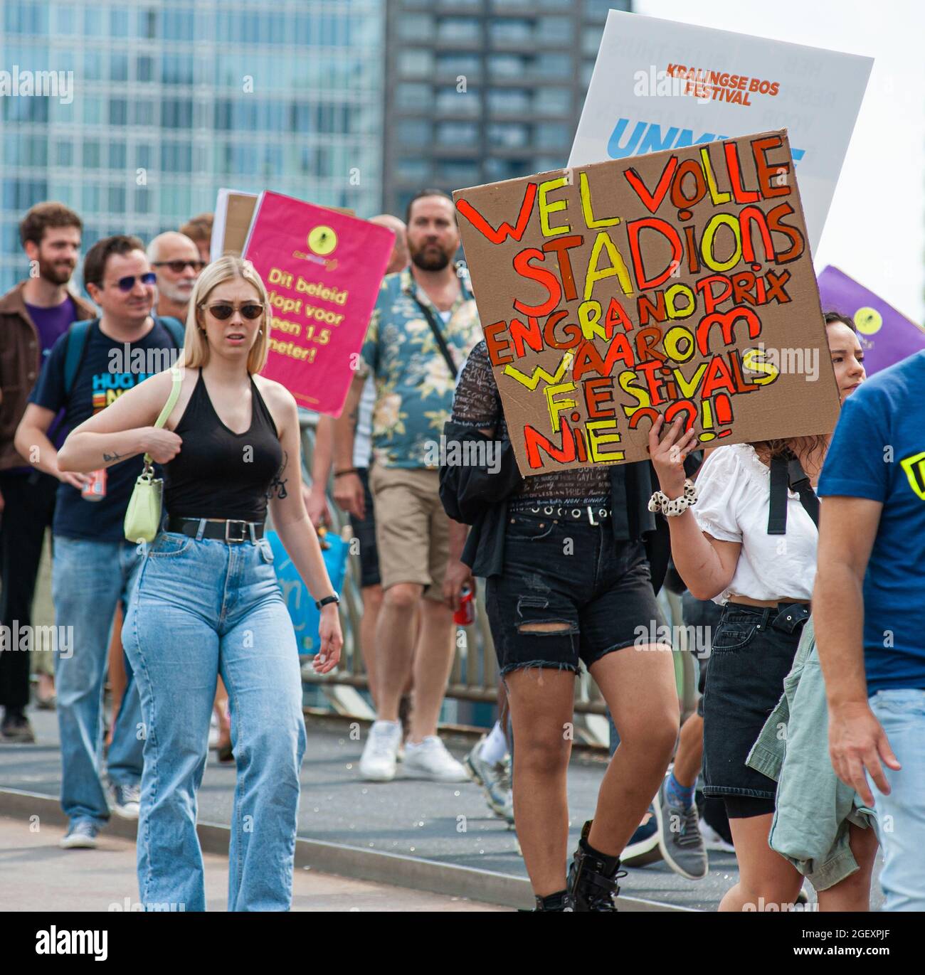 Protesters hold placards expressing their opinion over Erasmus Bridge, in route to Stadhuisplein during the demonstration.Thousands of protesters took to the streets in six major cities' of the Netherlands. The demonstrators showed their disapproval regarding government measures or restrictions relating to the entertainment sector and, the Covid-19 pandemic; restrictions they consider to be of double standards. With the slogan ‘Unmute Us', they came out in large numbers in: Amsterdam, Rotterdam, Groningen, Eindhoven, Nijmenrgan and Utrecht. Demonstrations are demanding the events sector shoul Stock Photo