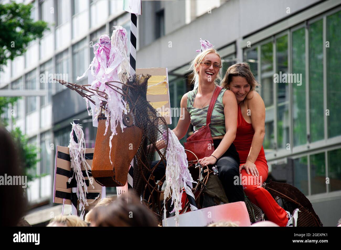 Two girls on top of a horse statue during the demonstration in Stadhuisplein.Thousands of protesters took to the streets in six major cities' of the Netherlands. The demonstrators showed their disapproval regarding government measures or restrictions relating to the entertainment sector and, the Covid-19 pandemic; restrictions they consider to be of double standards. With the slogan ‘Unmute Us', they came out in large numbers in: Amsterdam, Rotterdam, Groningen, Eindhoven, Nijmenrgan and Utrecht. Demonstrations are demanding the events sector should open its doors to full capacity as of the 1 Stock Photo