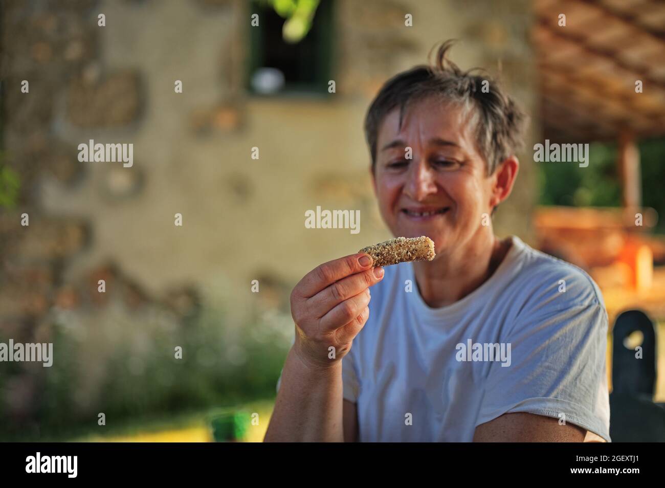 Portrait of mature woman holding homemade cookie Stock Photo