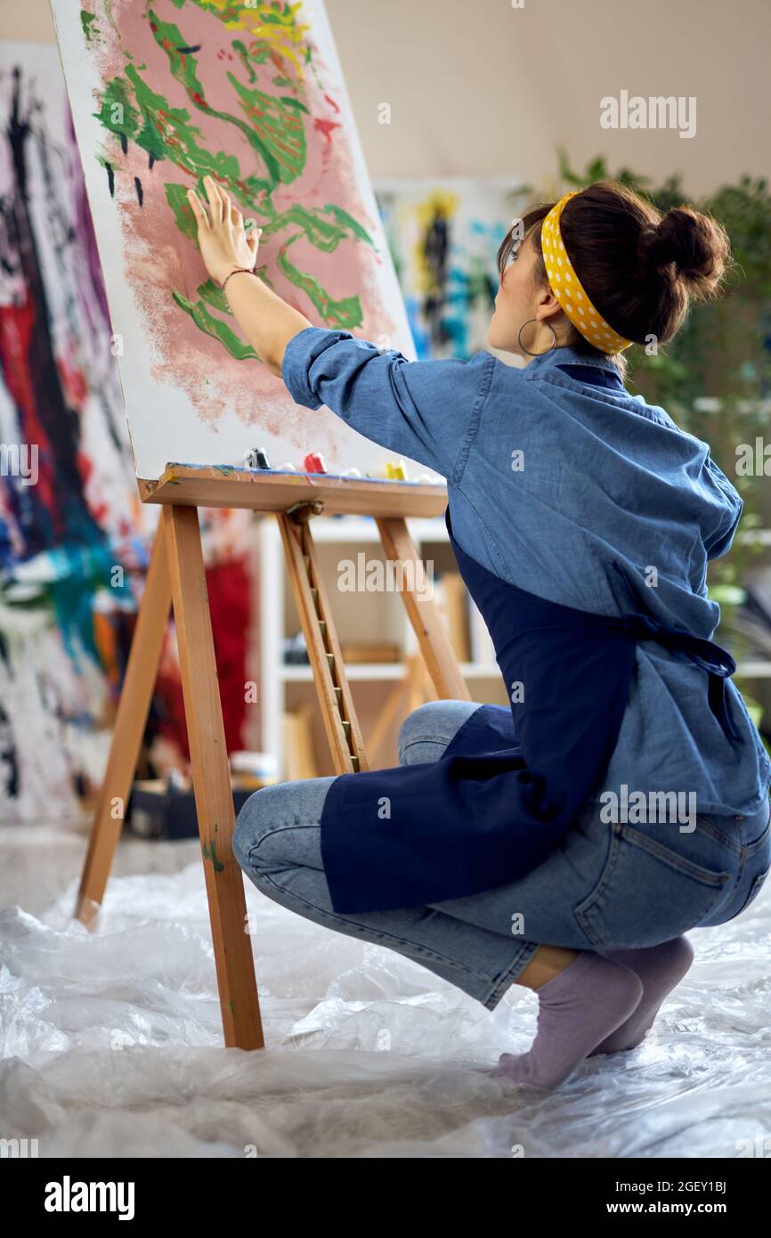Creative woman, female artist in apron creating her own abstract ...