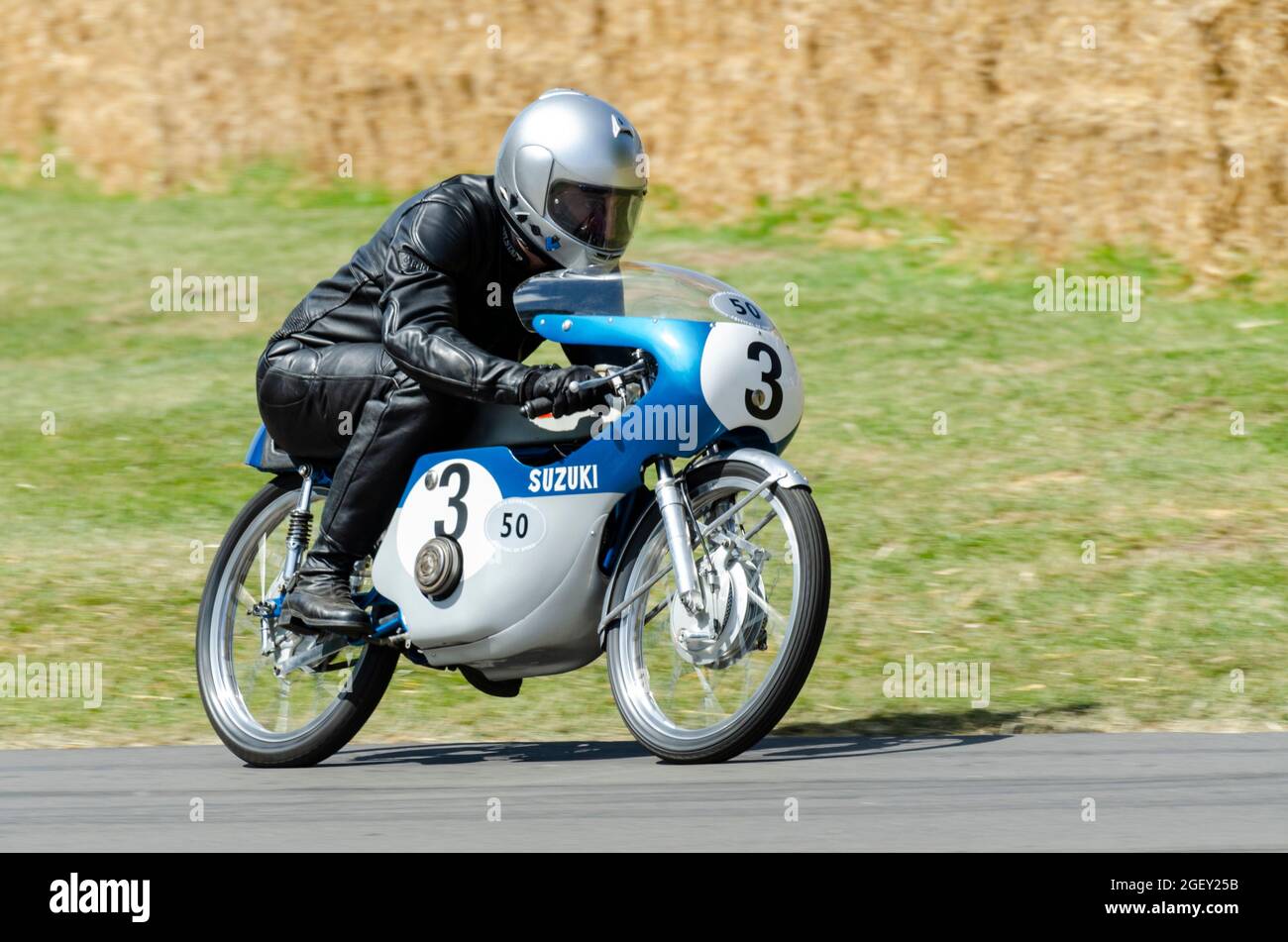 1964 Suzuki RM50 motorcycle racing up the hill climb track at the Goodwood Festival of Speed motor racing event 2014. Small motorbike Stock Photo