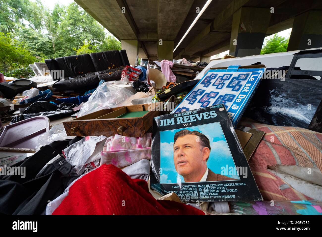 A huge amount of illegal fly tipping waste from construction sites and households dumped under the M8 viaduct, Glasgow, Scotland Stock Photo