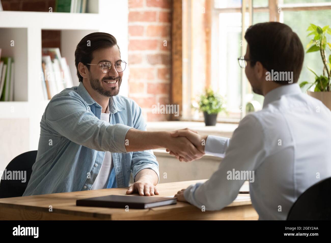 Two confident successful business partners shake hands start negotiations Stock Photo
