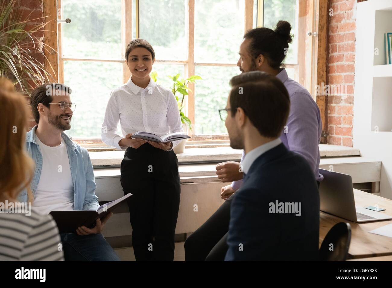 Multi ethnic teammates discussing common project at briefing in office Stock Photo