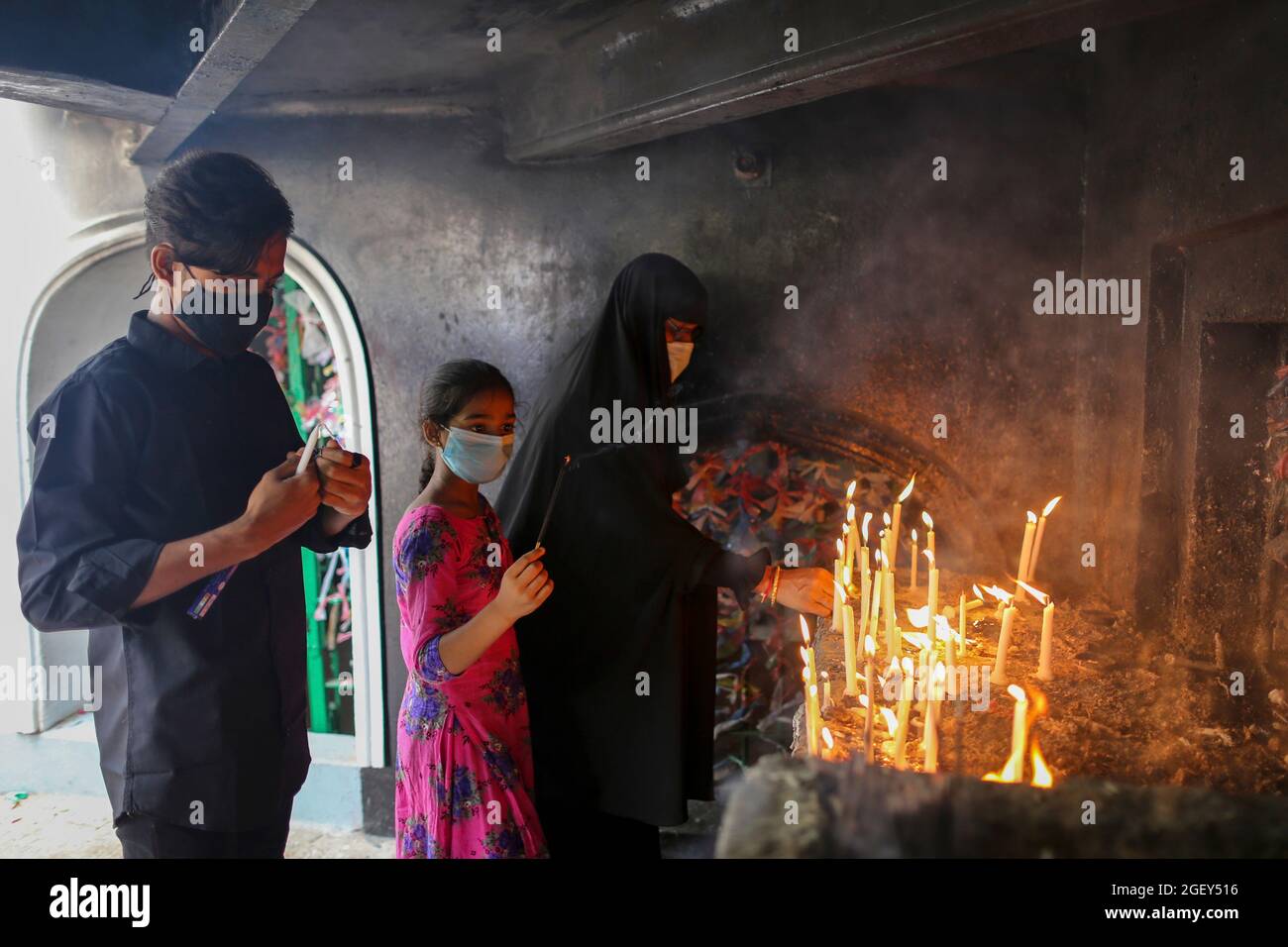 DHAKA, BANGLADESH, AUGUST 20: A Shia muslim woman lights a candle and pray for imam hussain, at Husani-dalan. Musilm People take part during  a religious procession in the month of Muharram on the occasion to commemorate  Ashura Day. Ashura is the tenth day of Muharram, the first month of the Islamic calendar commemorating the martyrdom of Imam Hussein, the grandson of the Prophet hazrat Muhammad. On August 20, 2021 in Dhaka, Bangladesh. Stock Photo